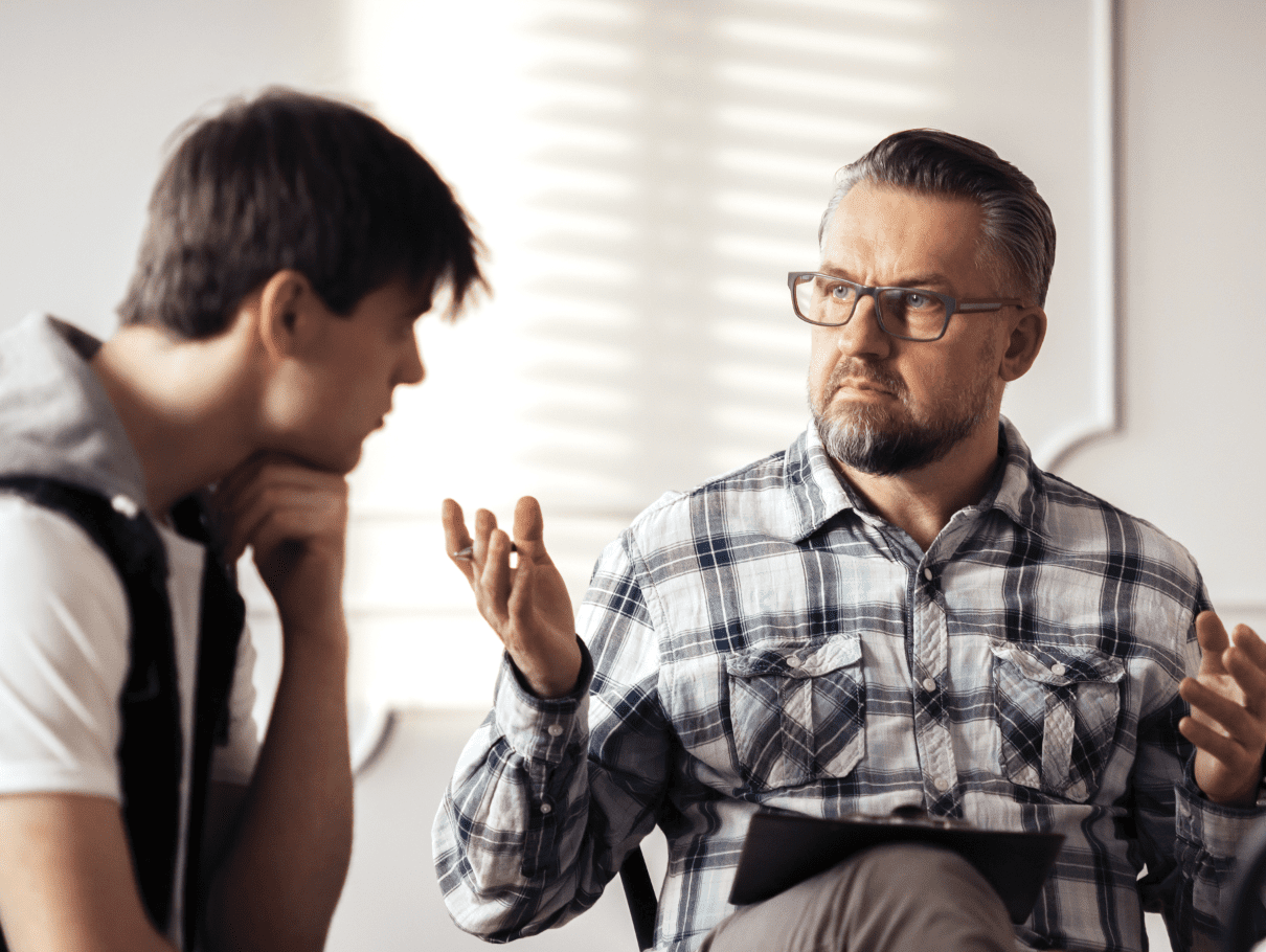 Older man explaining something to a younger man