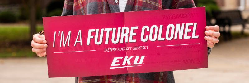 student holding a banner that says "I'm a future colonel" Eastern Kentucky University with logo