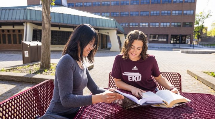 Two ASL students study in front of the Wallace Building.