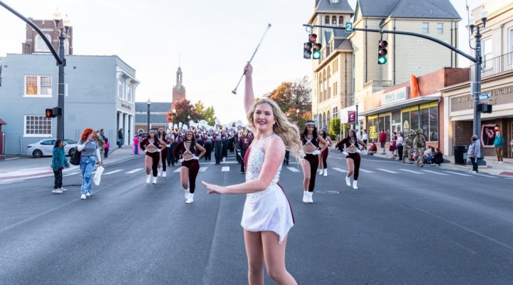 a baton twirler performs on the street during a parade