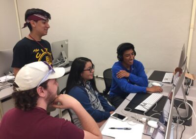 smiling students using desktop computers