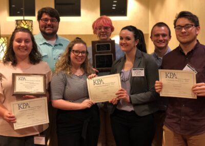 students pose with awards at a Kentucky Press Association event