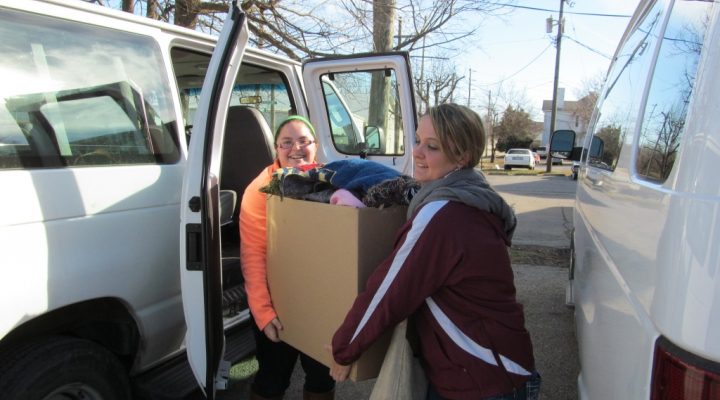 students carrying a box of donations