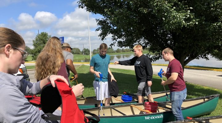 students load canoes with trash collection supplies