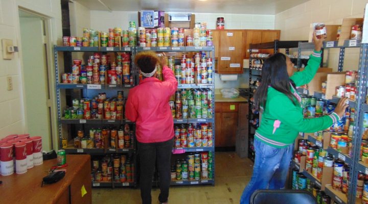 students stack food in the Colonel's Cupboard