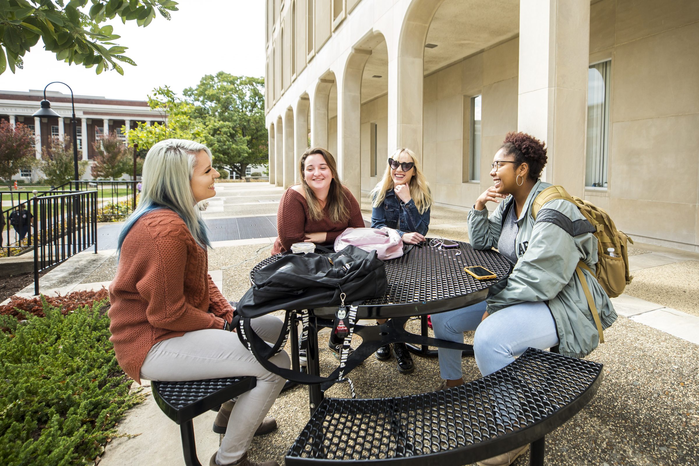 Students talk and laugh at a round table on Campus Beautiful.