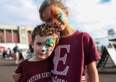 Two kids with face paint pose for a photo