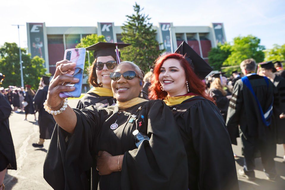 Three students take a selfie at Graduate Commencement.