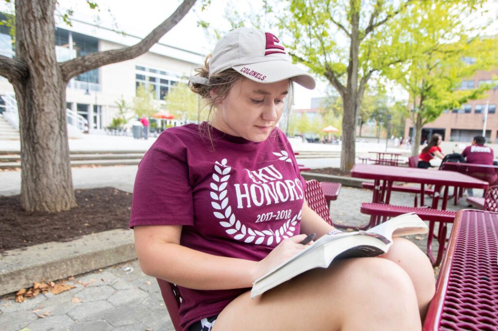An EKU Honors student studies outside