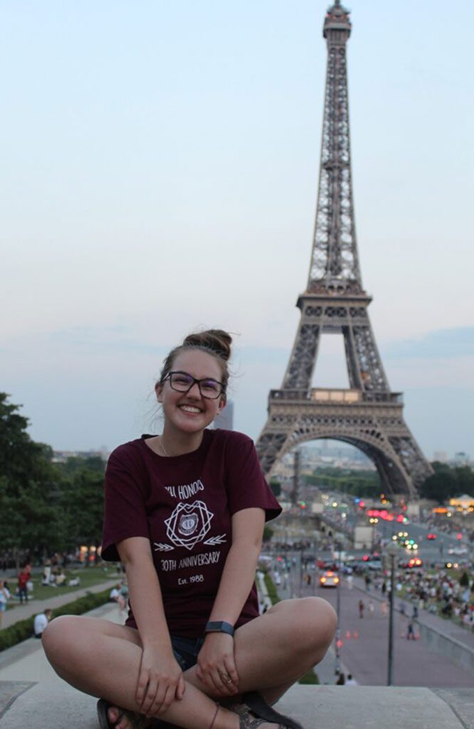 An EKU Honors student smiles in front of the Eiffel Tower