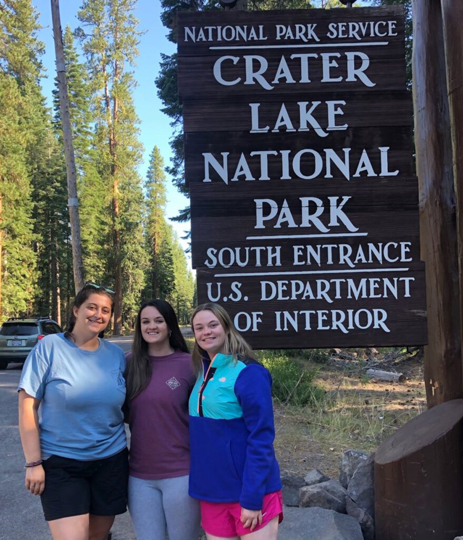 three EKU Honors students smile at Crater Lake National Park