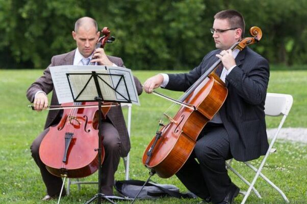 men playing cellos outside