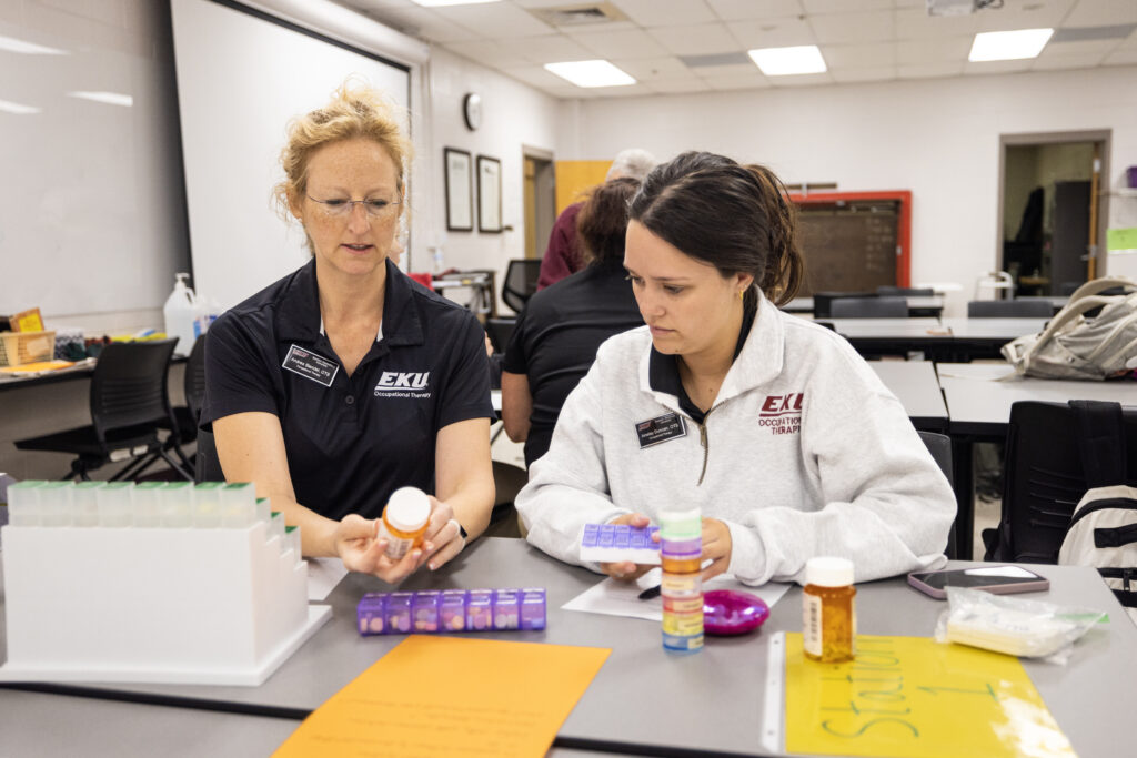A student and professor examine different medications used in physical therapy