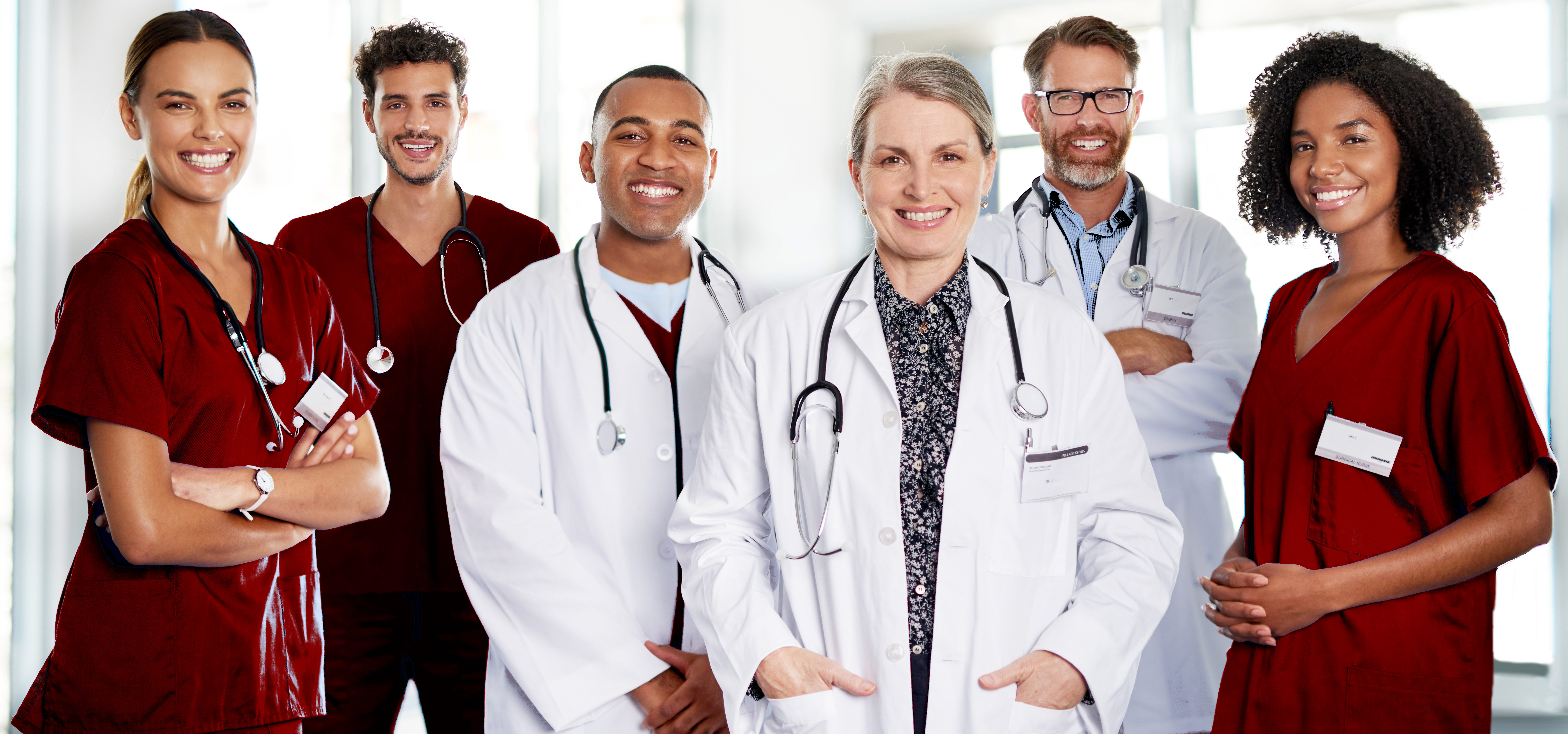 Six osteopathic medical professionals in scrubs and white coats
