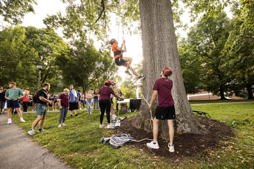 A student repels up a tree at the 2023 Rec the Ravine