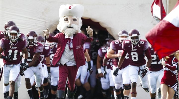 An image of Eastern Kentucky University football players and the Colonel mascot running onto the football field.