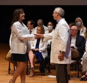 Ms. Emily Paulin receives congratulations from Dr. Chipper Griffith, UK acting dean of medicine, at white coat ceremony.