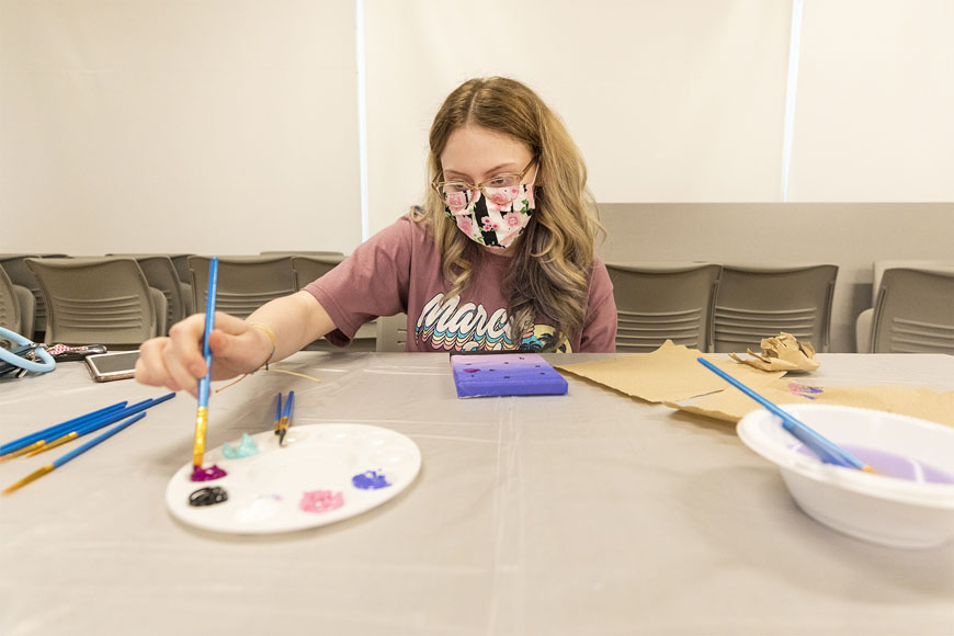One student painting on a canvas during Big E Welcome at the Recreation Center