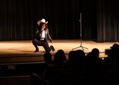 Student in cowboy hat performs on stage