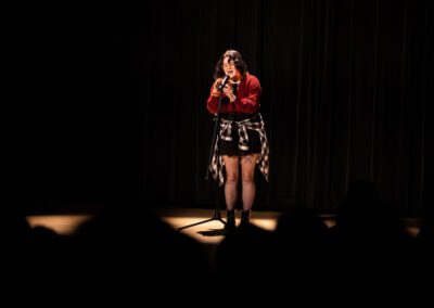 Student sings into microphone on stage