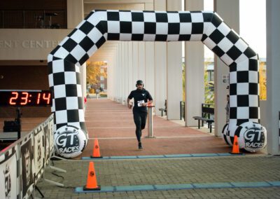 Runner crosses finish line at 5k event