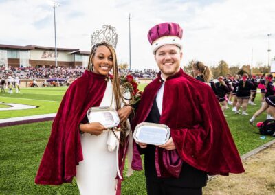 Homecoming king and queen in crowns pose together