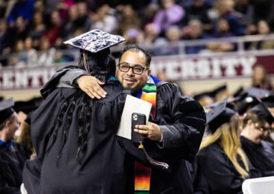 Two graduating students hugging