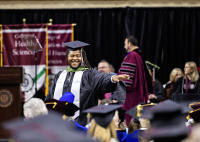 An excited student smiles after receiving diploma