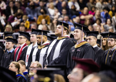 A row of graduating students stand during ceremony