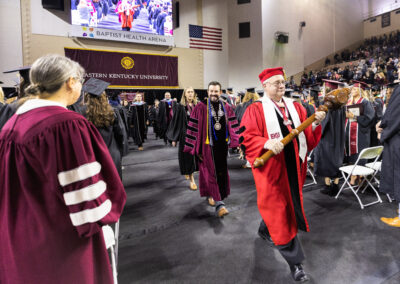 EKU President McFaddin in maroon gown walks down aisle