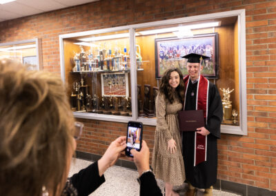 A graduate and family member pose for a photo