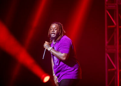 T-Pain performs on stage surrounded by red stage lighting