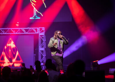 T-Pain performs on a stage aglow with red stage lights