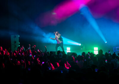 T-Pain performs on stage surrounded by multicolor stage lighting