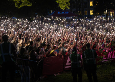 concert goers raising phones to light the ravine
