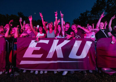 Students pose in front of an EKU banner at the Lil Jon concert