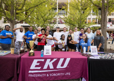 Students at the Fraternity and Sorority Life table pose for a photo