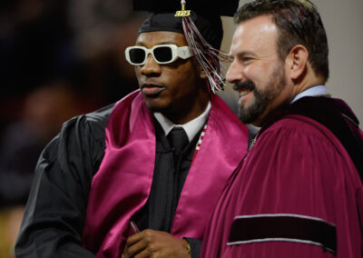 A graduate at Eastern Kentucky University's Fall 2023 Commencement ceremony taking a picture with the president.
