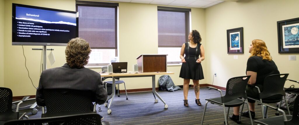 an honors student presents a thesis on a screen in a classroom