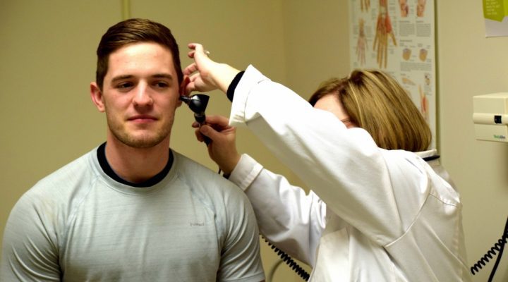 Someone getting their ear checked by a medical professional.