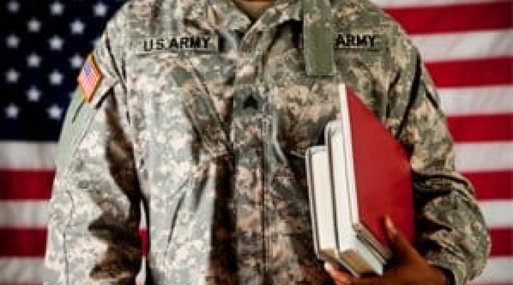 An image of an Army member standing in front of the American flag holding books.