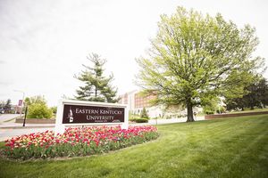 Eastern Kentucky University sign at campus entrance with tree - link to EKU Payroll Calendar