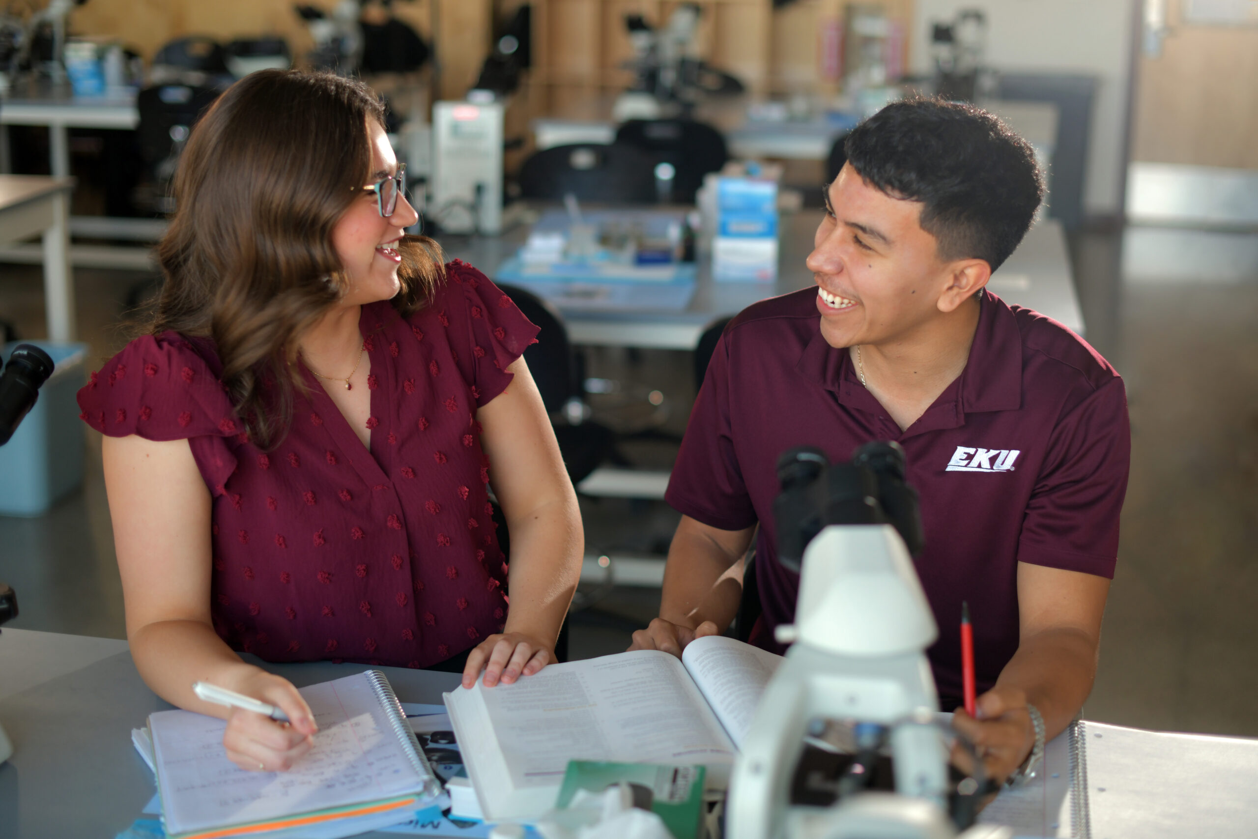 Two Students sitting at a lab bench smiling