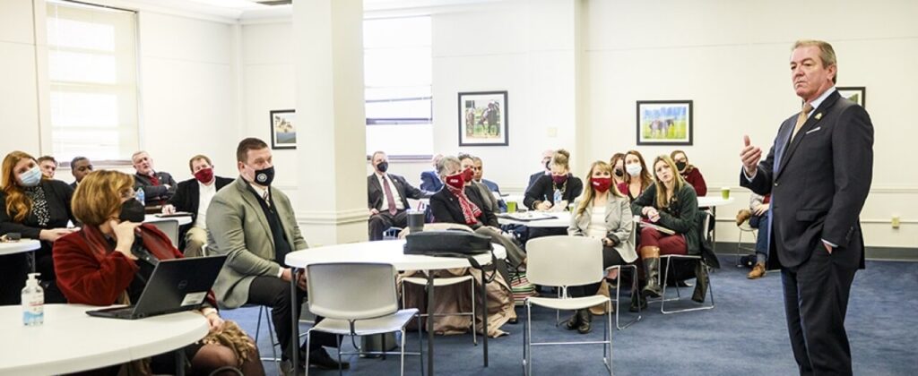 A group of EKU faculty and staff listen to speaker in a large room.