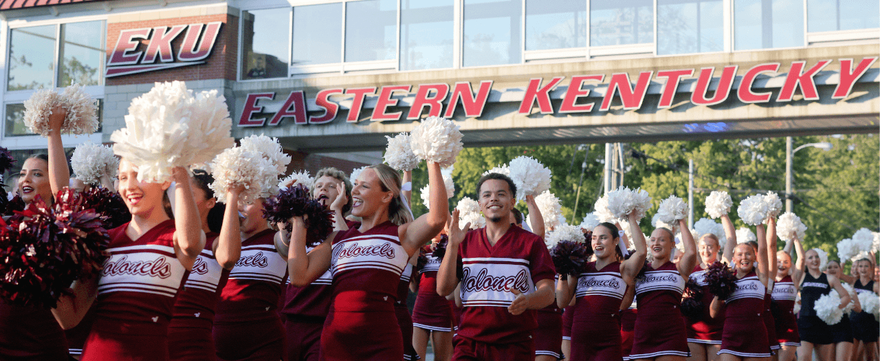 large group of EKU cheerleaders in the foreground with the EKU pedway in the background