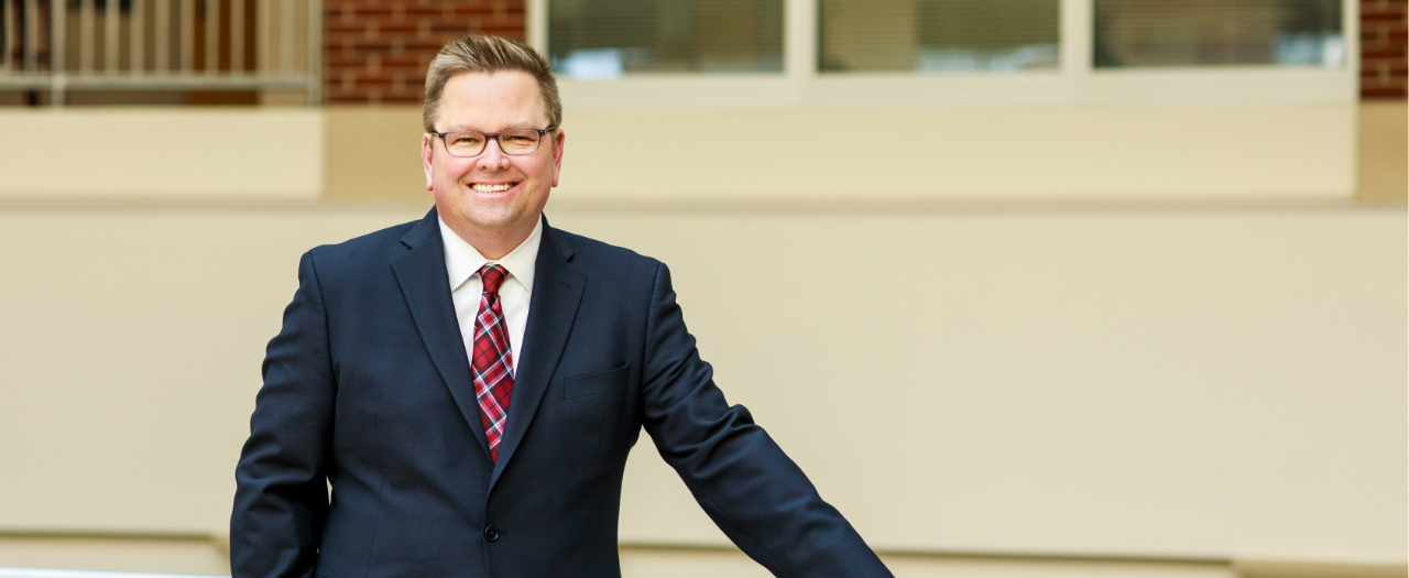Dean Tom Martin standing in front of the College of Business