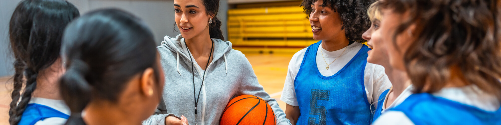 a group of basketball players gather around a coach