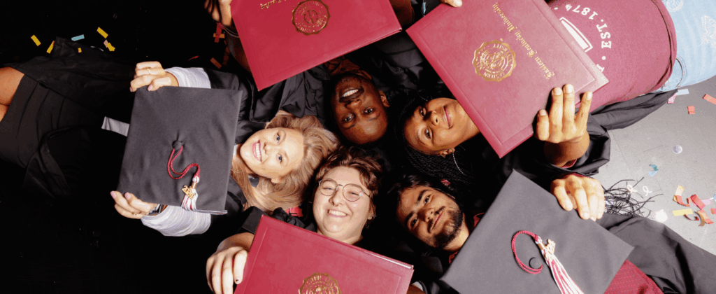 A group of happy seniors display their diplomas and smile.