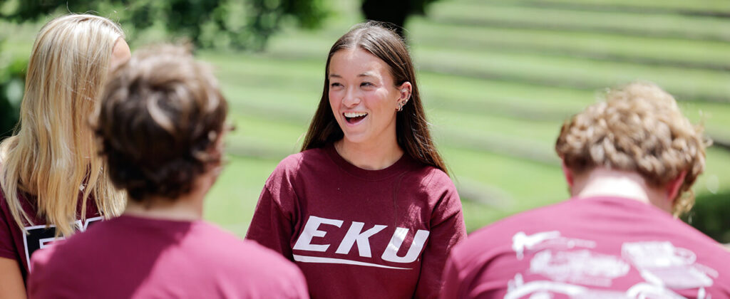 group of students in EKU shirts talking in the ravine