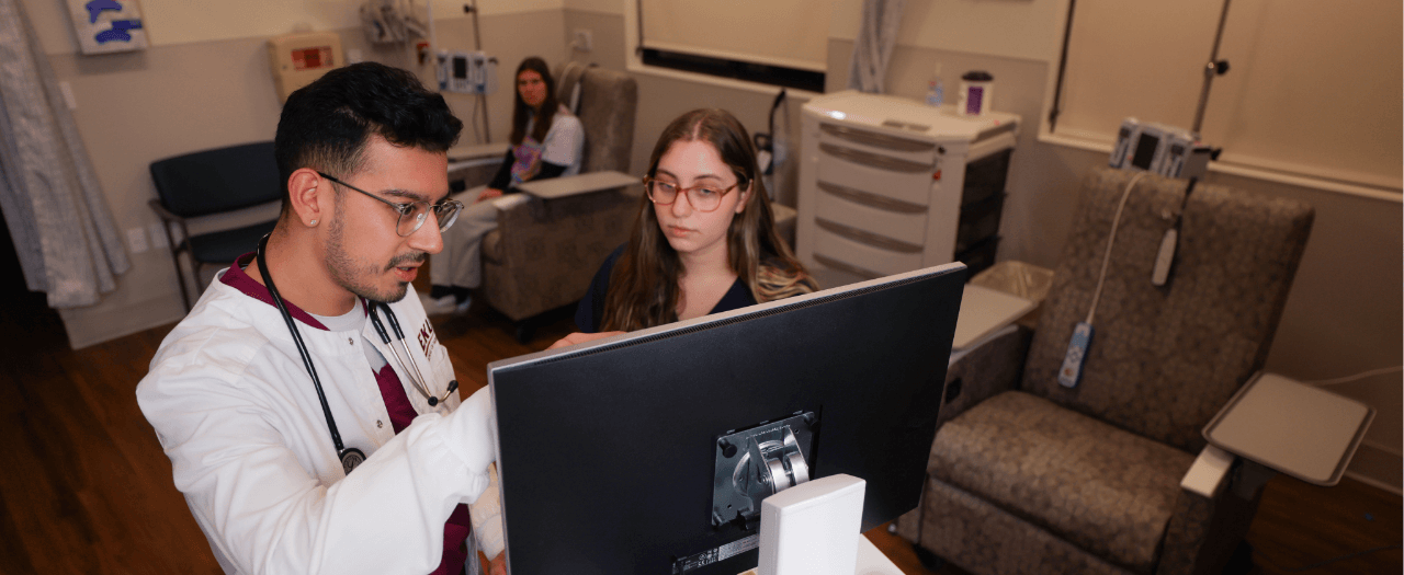 eku nursing students look at a monitor in a room with medical equipment